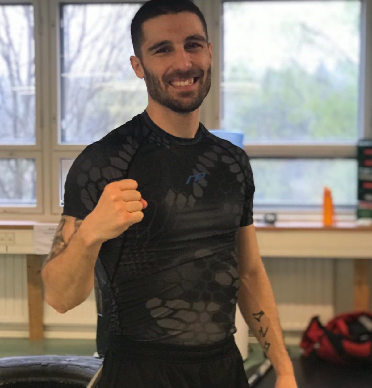 José Antonio Sánchez Rayito smiling waist-up portrait with clenched fist inside the boxing gym