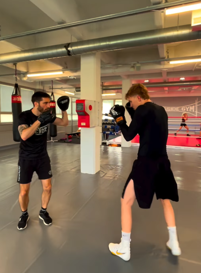 Full-body vertical pad-work coaching in the gym with focus mitts