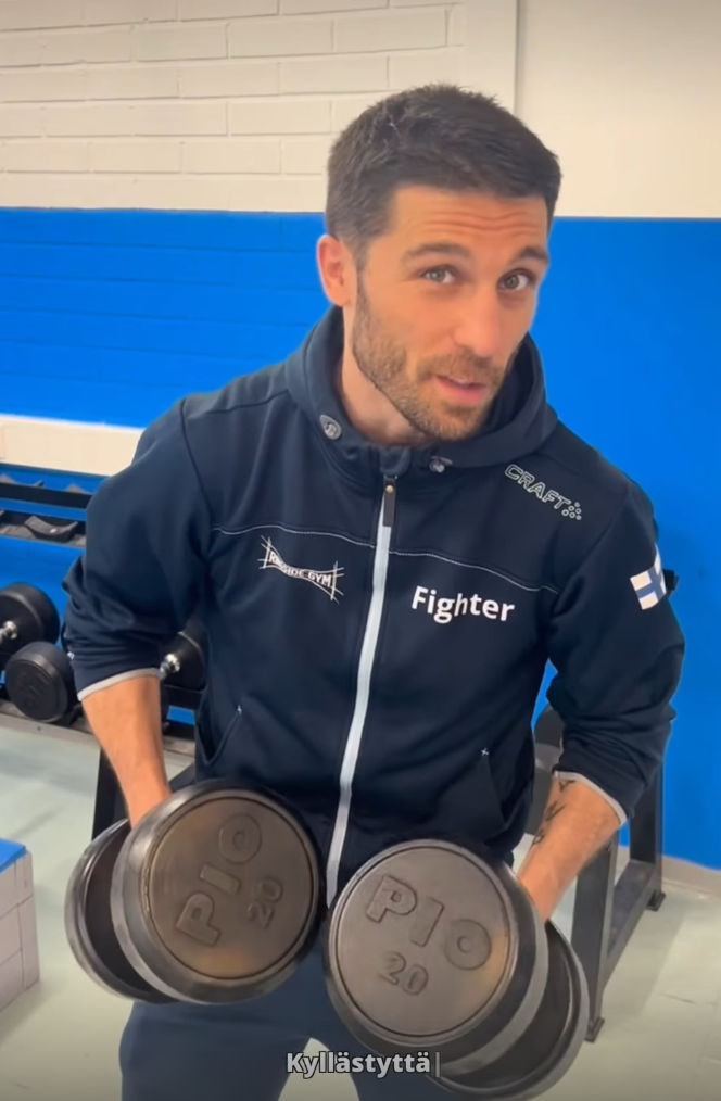Professional boxer Rayito holding heavy dumbbells during athletic gym conditioning